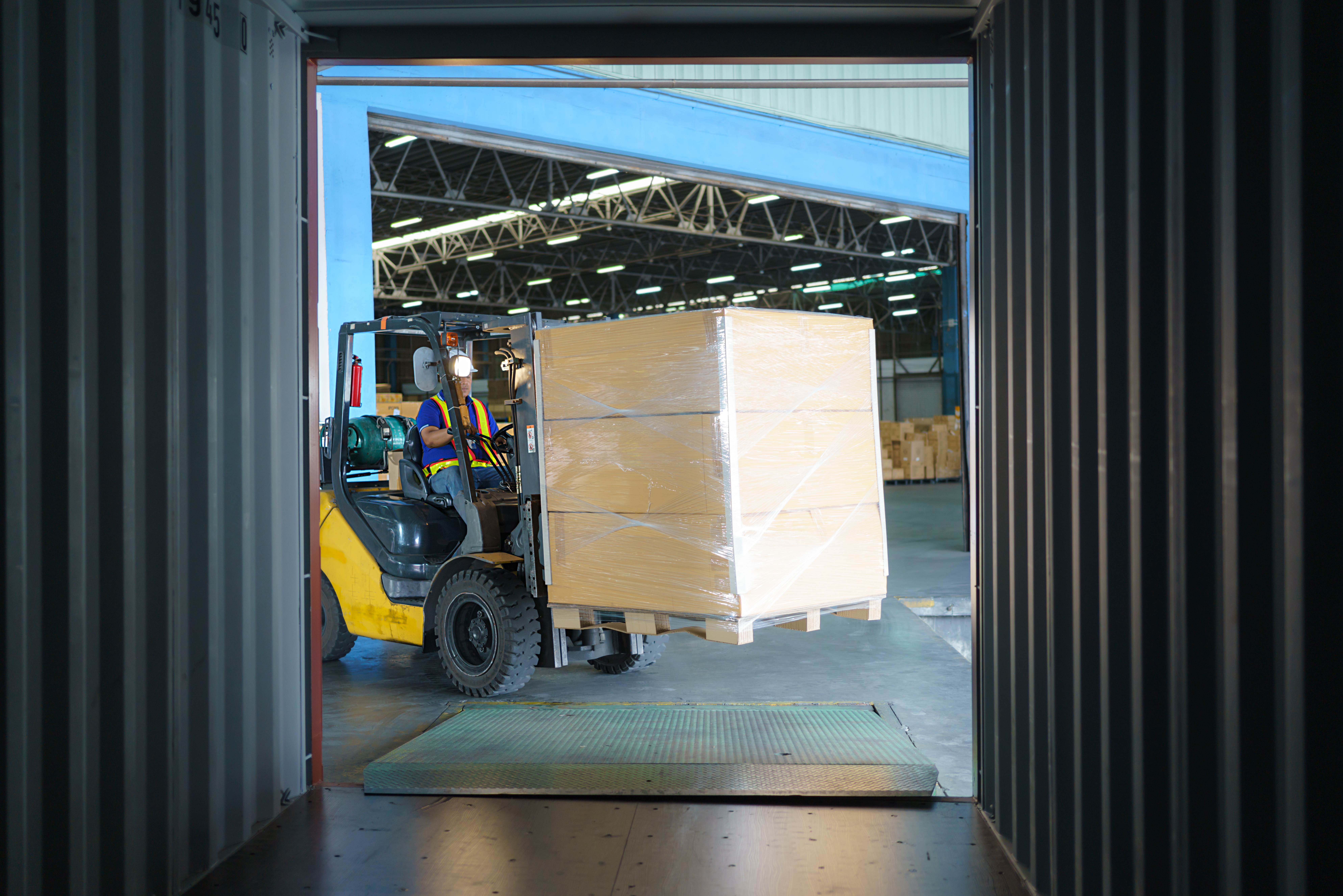 An image of outsourced warehouse workers who know how to make a warehouse more efficient unloading a trailer. 